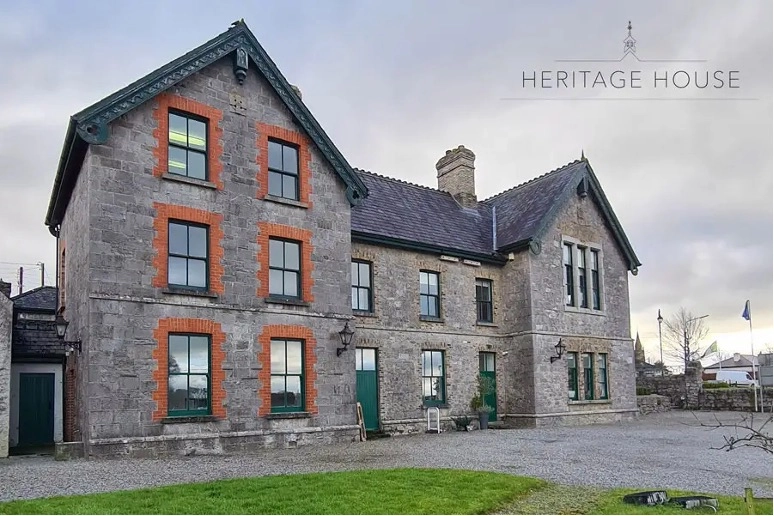 A large stone building with three storeys, featuring red brick trim around the windows, a dark roof, and a gravel courtyard. Preston House is written in the top right corner with a small emblem above it.